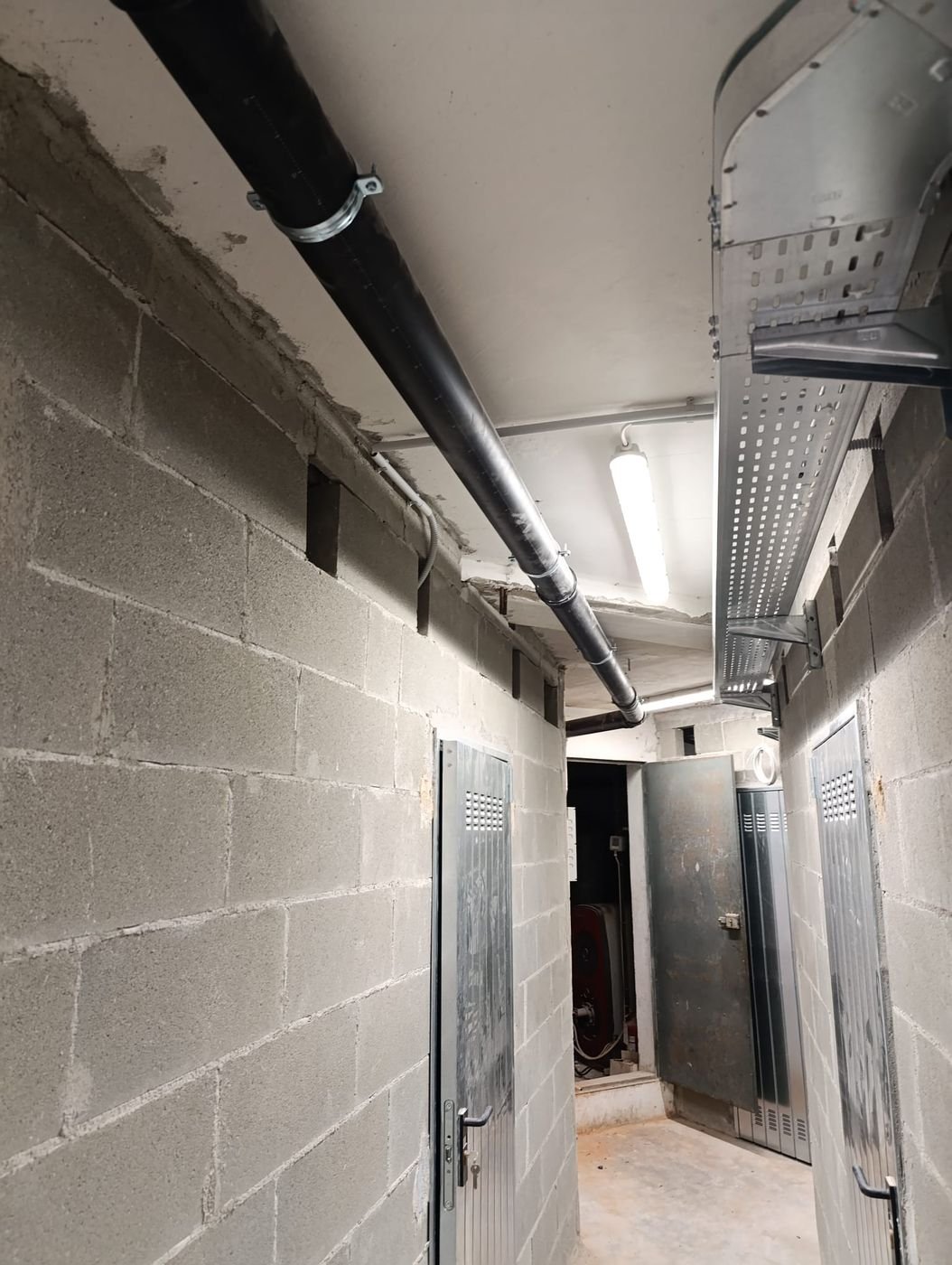 Corridoio di un'autorimessa con canalina portacavi e plafoniere a led