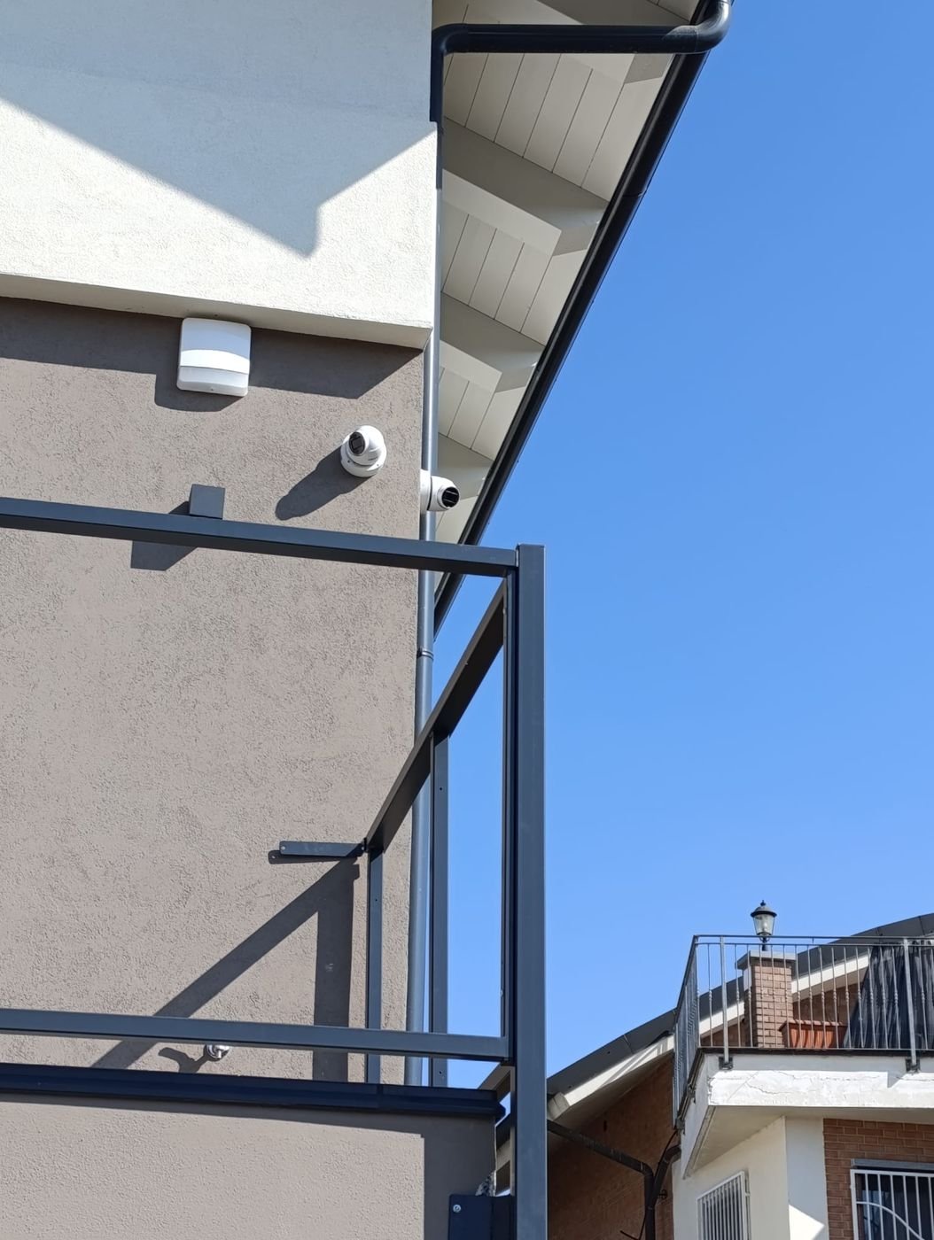 Telecamere dome per videosorveglianza e sensore installati su una facciata da DM Impianti Elettrici