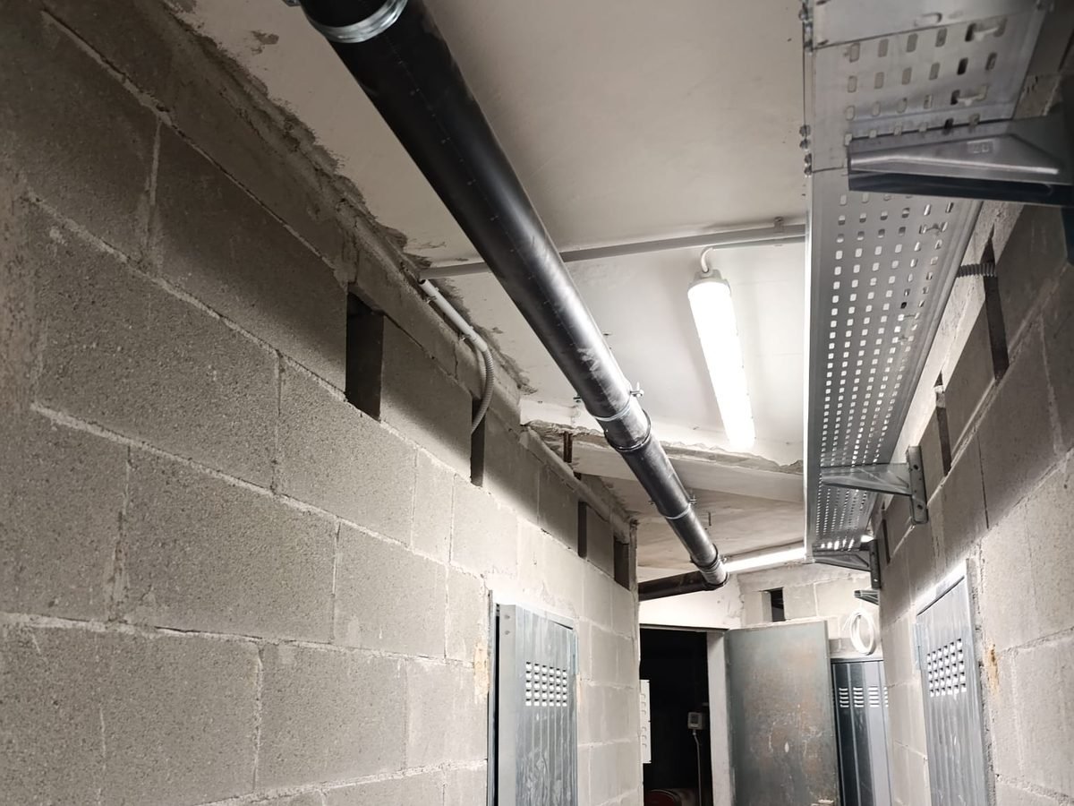 Corridoio di un'autorimessa con canalina portacavi e plafoniere a led installate da DM Impianti Elettrici