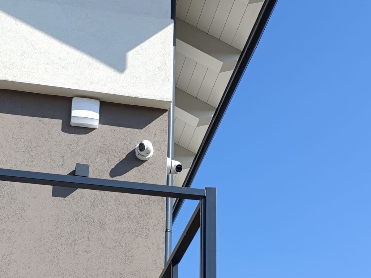 Telecamere dome per videosorveglianza e sensore installati su una facciata da DM Impianti Elettrici